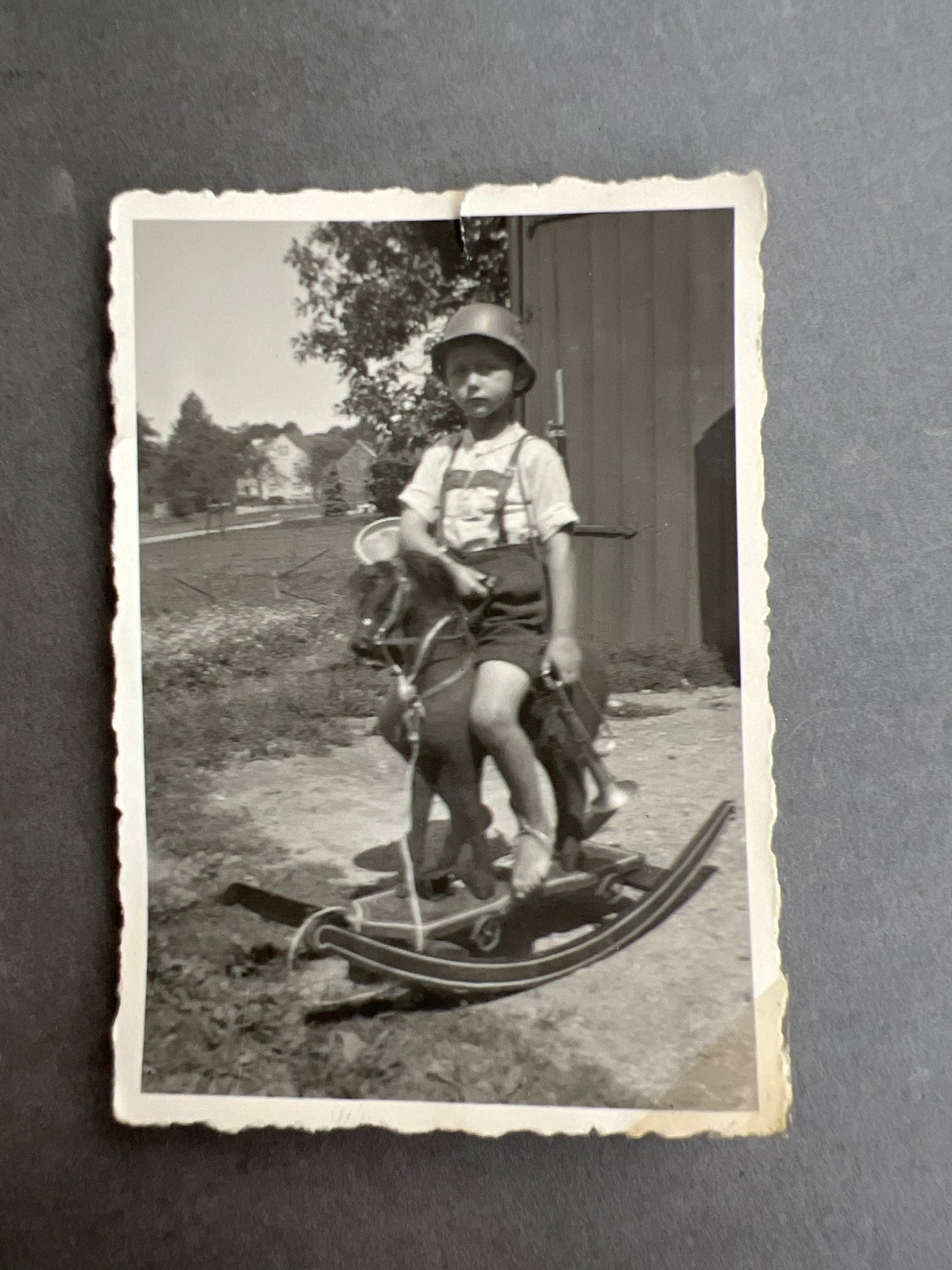 WW2 Tysk Foto af dreng med legetøjshjelm, trompet, gevær, gyngehest mv. Original.