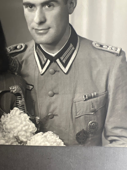 WW2 Tysk Stort "Studiofoto". Soldat i sommer kampuniform, med sabel, skydesnor, medaljer mv. Original.