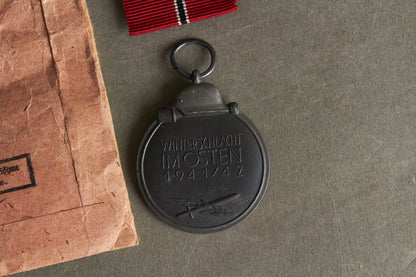 WW2 Tysk Sæt Østfront Medalje i pose. Pose og Medalje fra samme fremstiller. Stemplet "93" for "Richard Simm & Sohne". Original.