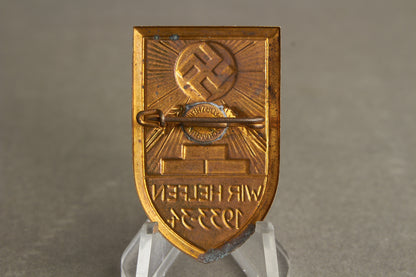WW2 Tysk Tidlig 1933/34 "Wir Helfen" WHW/NSDAP Tinnie. Sjælden. Original.